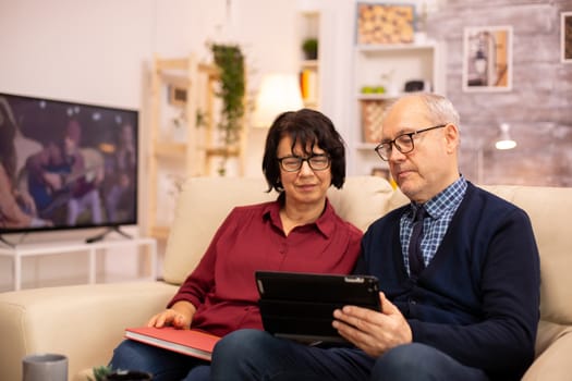 Beautiful old couple using a digital tablet to chat with their family. Elderly people using modern technology