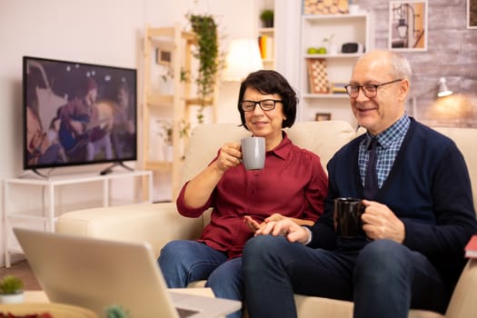 Elderly old couple using modern laptop to chat with their grandson. Grandmother and grandfather using modern technology