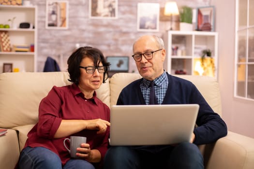 Elderly old couple using modern laptop to chat with their grandson. Grandmother and grandfather using modern technology