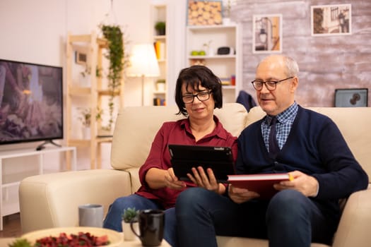 Beautiful old couple using a digital tablet to chat with their family. Elderly people using modern technology