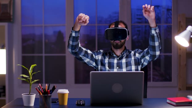 Caucasian businessman in home office wearing virtual reality goggles. Bearded businessman using modern technology.