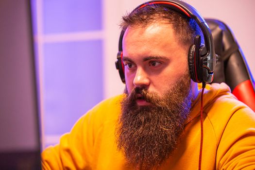 Close up portrait of professional bearded video gamer in front of his PC