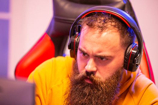 Close up portrait of professional bearded video gamer in front of his PC