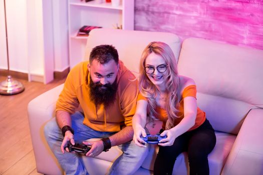 Beautiful girlfriend trying to make her boyfriend lose while playing video games on console.