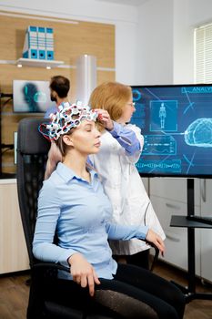 Doctor preparing brain waves scanning headset for tests. Doctor scanning brain activity