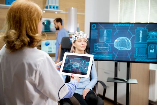Doctor who looks at the evolution of the patient's brain on the tablet. Neurology lab