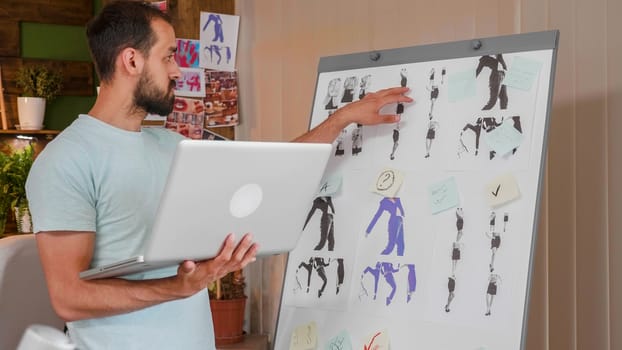 Young designer working on whiteboard and holding a laptop. Creativ agency