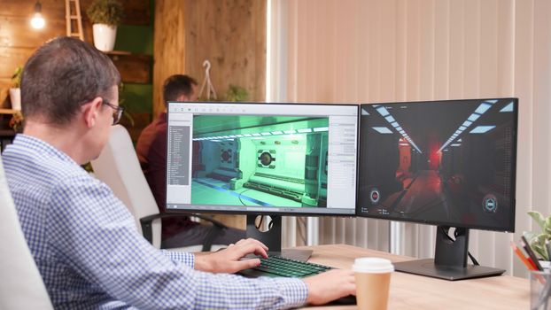 Team of video games creators showing graphics on computer display. Gaming software on pc.