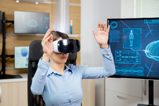 Female student learns neurology with vr glasses in futuristic laboratory. Research medical