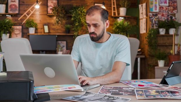 Young designer working on a laptop in a creative and cozy space. Creative agency and cool work space