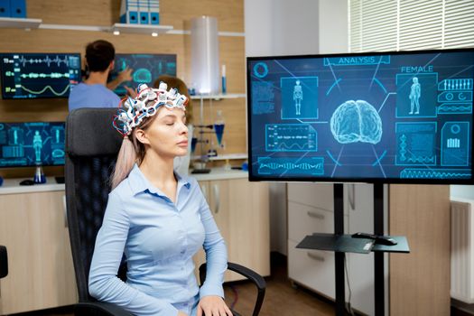 Female patient who is in a neurology clinic and her brain is being scanned. Brain waves scanning headset