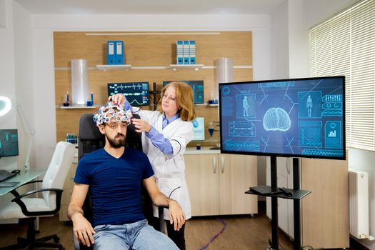 Doctor tracking data transmitted by brainwaves scanning headset. Neurology lab