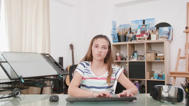 Teenage girl chatting with somebody on the internet. Portrait of a kid using her computer to do homework.