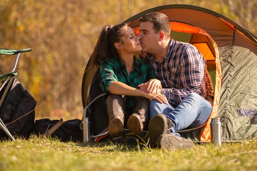 Couple in love kissing in front of the tent. Happy couple