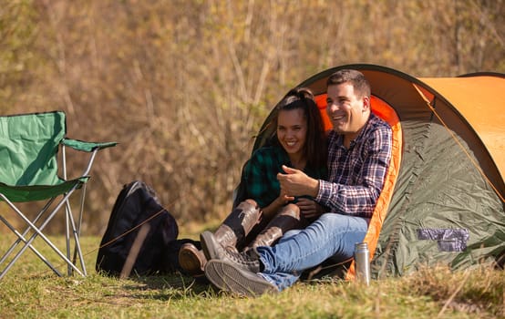 Couple of lovers smiling in front of the tent. Happy happy people