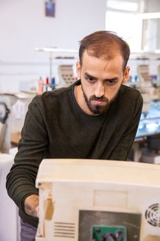 Worker at the textile factory who develops an industrial embroidery machine. Industrial background