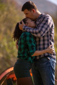 Man kissing his girlfriend on the head in a mountain background. Romantic vacation