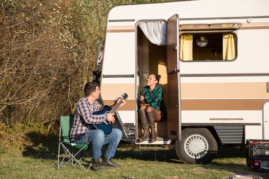 Happy couple enjoying their relationship in the mountains with their retro camper van.