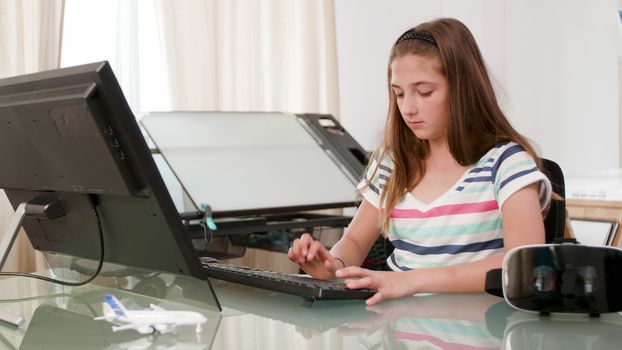 Teen girl installing software for her new vr headset. Installing a virtual reality headset on her computer.