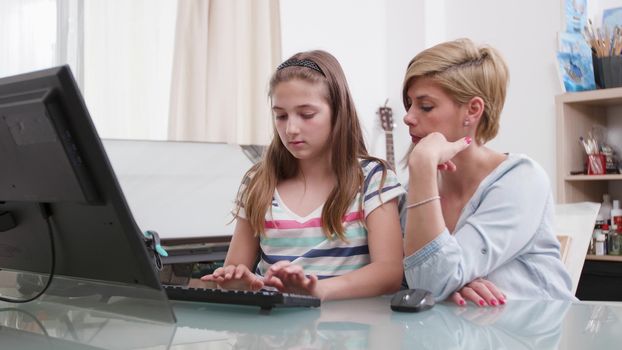 Mother helping her daughter with homework. Responsible parent helping her teenage girl with a task for school.