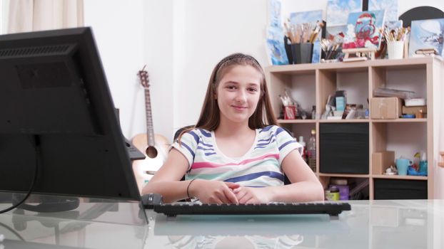 Teenage girl laughing and smiling to the camera. Slow motion shot on slider of a young girl in her room.