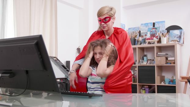 Young teenage girl gets stressed and her super mother comes to help. Adult woman in superhero costume and her daughter.