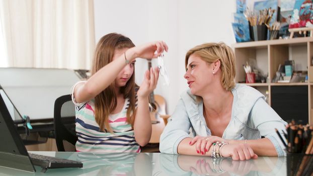 Young girl playing with a toy plane with her mother. family thinking about flying to a new destination.