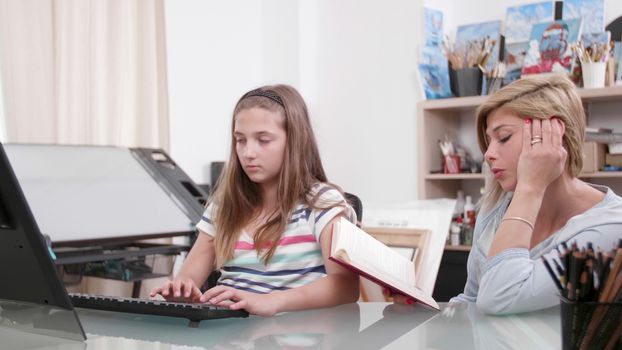 Mother dictates a text from a book to her daughter. Teenage girl writes a text from a book that her mother reads.