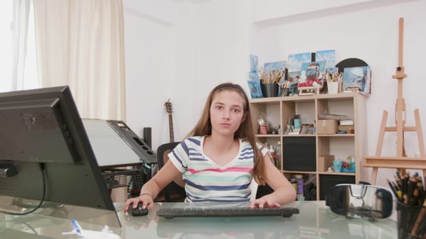 Girl in her room looking at virtual monitor. Cute girl working on a computer facing the camera.