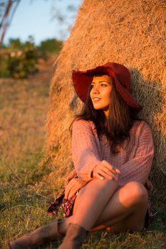 Portrait of young brunette woman in vineyard with stylish hat.