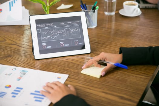Tablet with charts in the coferene room and business people.