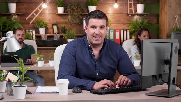 Portrait of smiling office worker in casual clothes. Zoom in slow motion shot