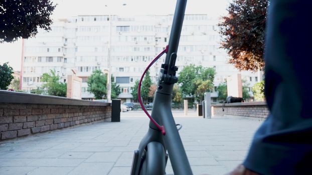 Man in formal suit riding an electric scooter in the city. Environmentally friendly businessman