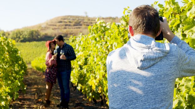 Photographer taking pictures of lovely couple in a vineyard.