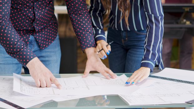 Professional architects drawing over blurprints, close up shot