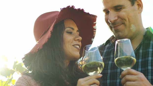 Beautiful couple tasting wine in lensflares. Wine tasting.