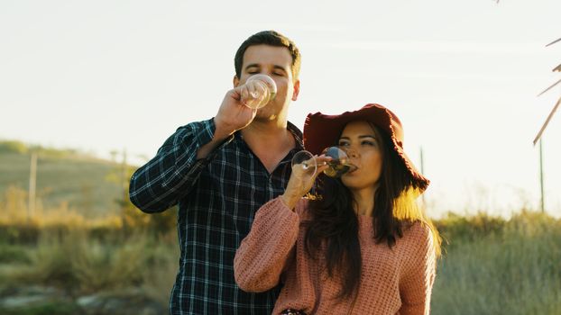 Inlove caucasian couple tasting delicious white wine in worm sunlight.