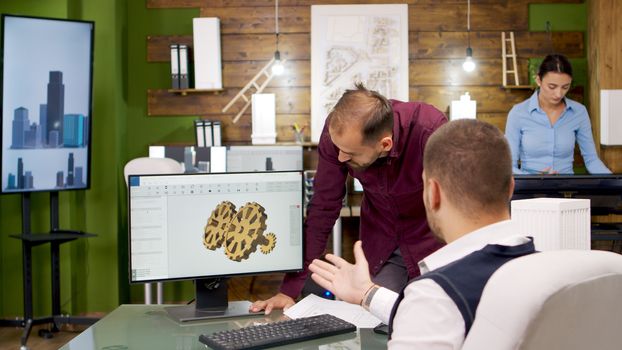 Team of creative architects working on computer. Architect having a discussion.