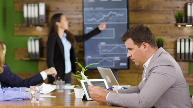 Businessman working in the conference room holding chars. Coworker presenting strategy in the conference room.