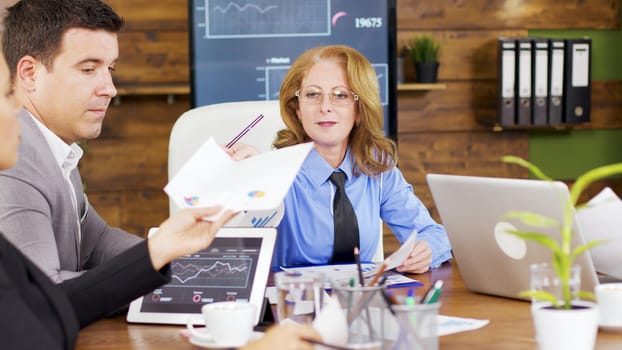 Corporate female business trainer discussing financial graph. Investment team in the conference room.