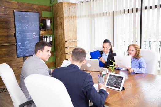 Adult people working productively on business project together in coference room.