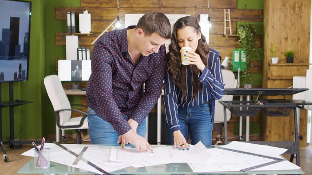 Team of architects working over blueprints in cozy office interior