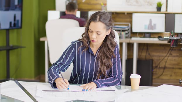 Designer in creative office space working on a new project at her table