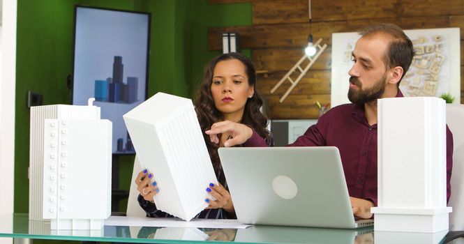 Team of creative designers working on new building models with 3D printed models