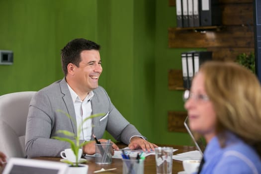 Caucasian businesin the conference room smiling wearing a suit. Happy leadership.