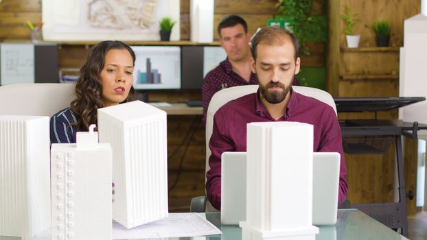 Team of architects and designers working on new 3D printed models and blueprints