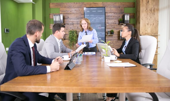 Group of business people having a meeting in a conference room. Business woman working on laptop.