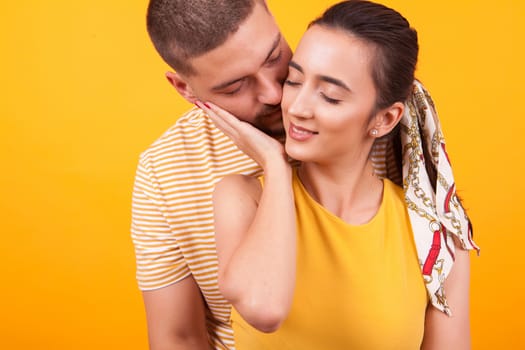 Happy girlfriend while boyfriend is kissing her from behind. Romantic couple.