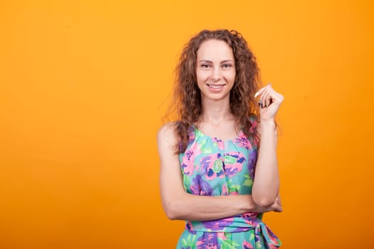 Portrait of young woman with hands crossed and carefree in studio. Joyful woman.