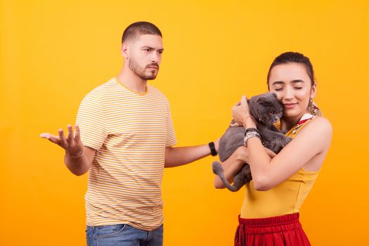 Gelous boyfriend on their cat for stealing affection from his girlfriend. Girl loving her cat.